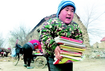 刘润琪高兴地搬着图书和文具.