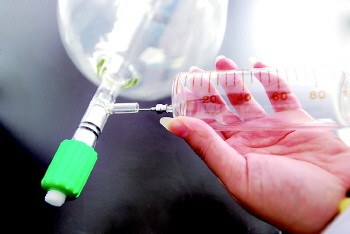 判定师用注射器将采样瓶中的空气样本抽出一部分.