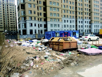 悦来新城小区围墙外堆积如山的垃圾.      本报见习记者 李翔昊 摄